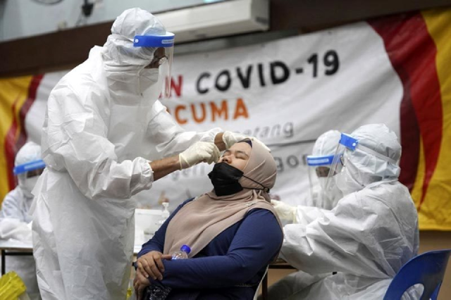 Nhân viên y tế Malaysia lấy mẫu xét nghiệm COVID-19 cho người dân.