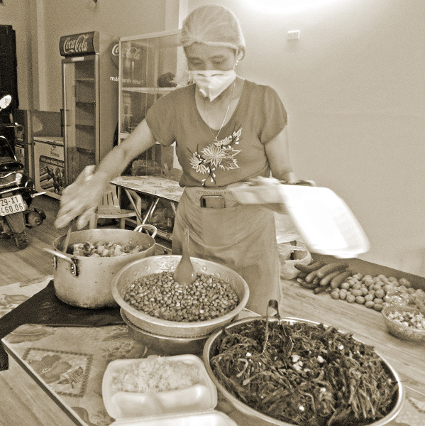 Chị Nguyễn Thị Chung đang nấu cơm phục vụ sinh viên, người lao động đang mắc kẹt trên địa bàn…