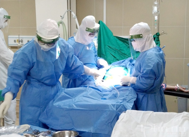 Các y, bác sĩ cơ sở 2, bệnh viện Phụ sản Hà Nội tiến hành ca mổ bắt con cho sản phụ dương tính với Covid-19.