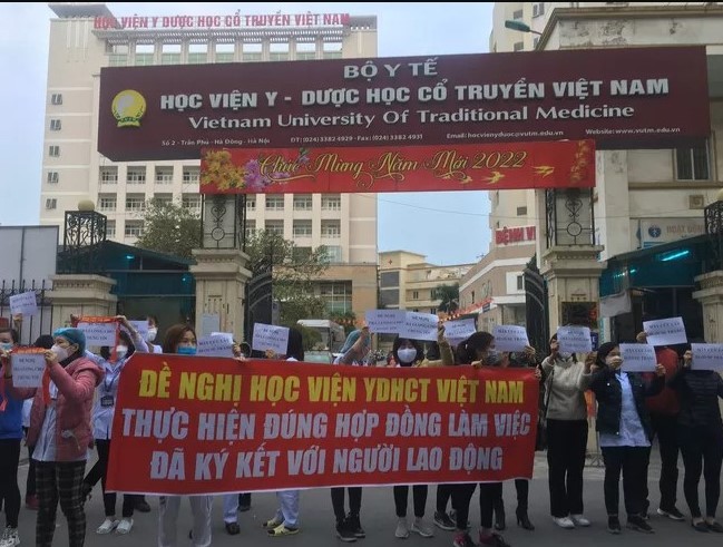 Hàng chục nhân viên y tế cầm băng rôn đề nghị Học viện Y dược học cổ truyền Việt Nam thực hiện đúng hợp đồng lao động