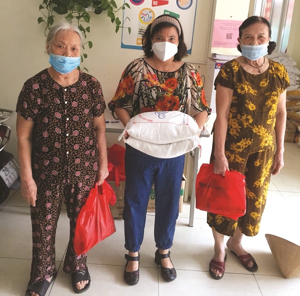Chị Phạm Thị Cúc Tú (người đứng giữa) tặng quà cho hội viên phụ nữ trên địa bàn có hoàn cảnh khó khăn do dịch Covid-19