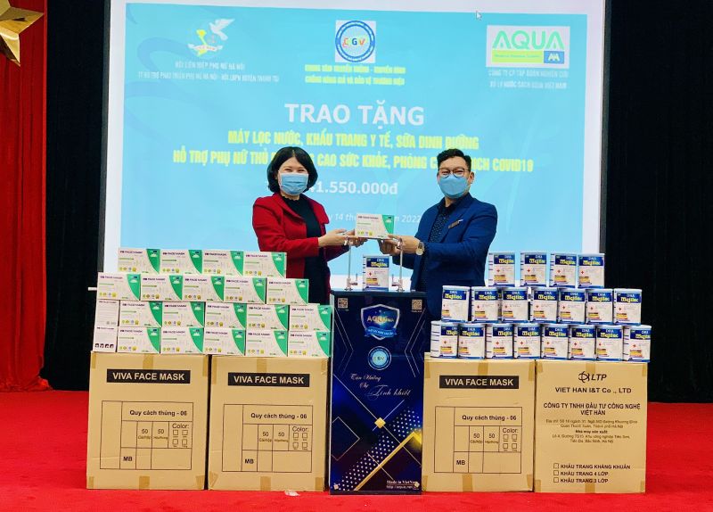 Bà Phạm Nguyên Nhung, Chủ tịch Hội LHPN huyện Thanh Trì nhận quà từ Công ty Aqua Việt Nam